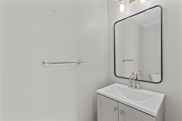 bathroom with vanity, ornamental molding, and toilet