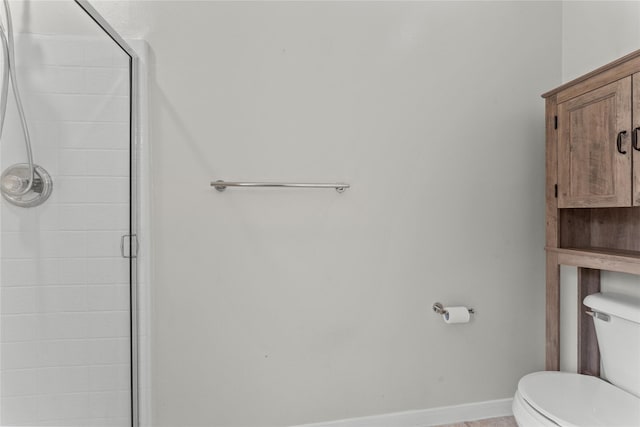 bathroom with toilet and a shower with shower door