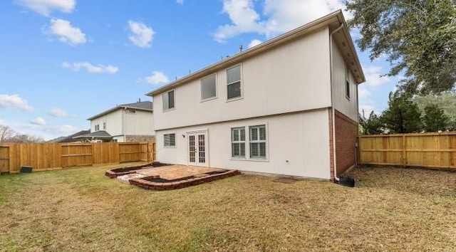 rear view of house with a lawn, a patio area, and french doors