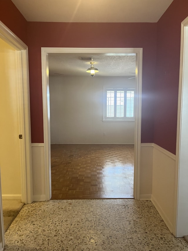 spare room with parquet floors and a textured ceiling