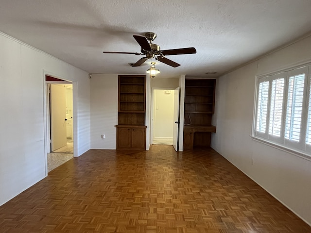 spare room featuring ceiling fan, parquet flooring, and a textured ceiling