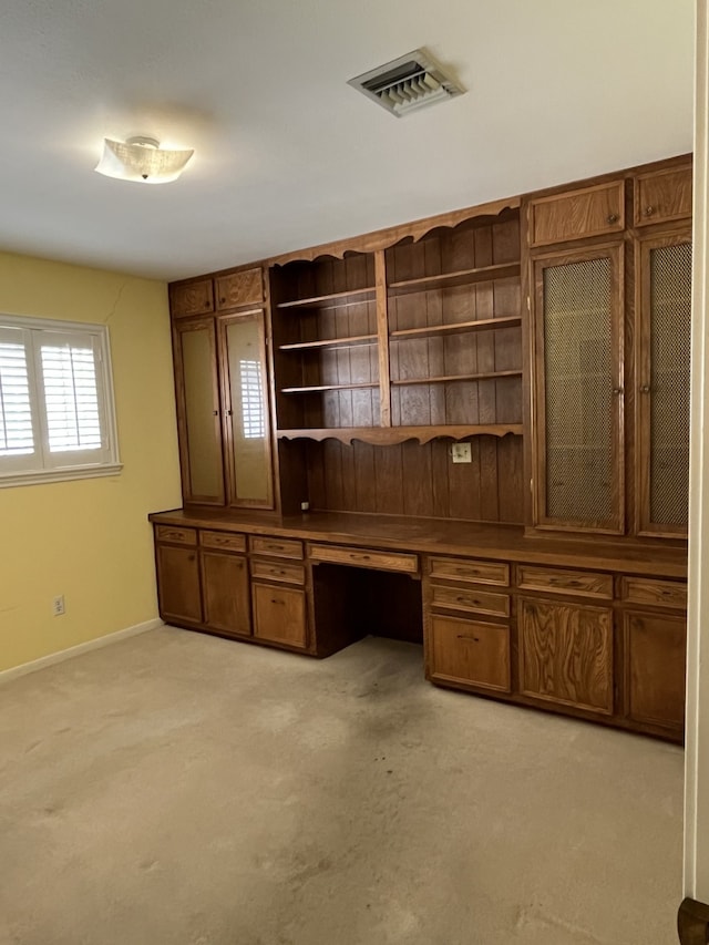 unfurnished office with light carpet and built in desk