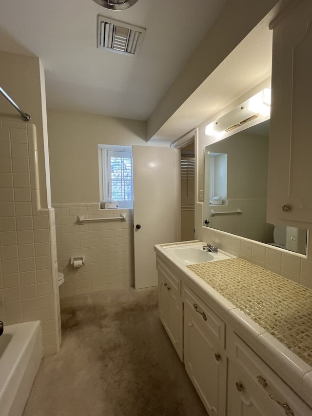 bathroom featuring vanity and tile walls