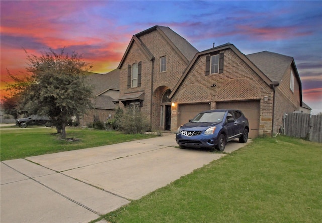 view of front of home with brick siding, a lawn, fence, a garage, and driveway