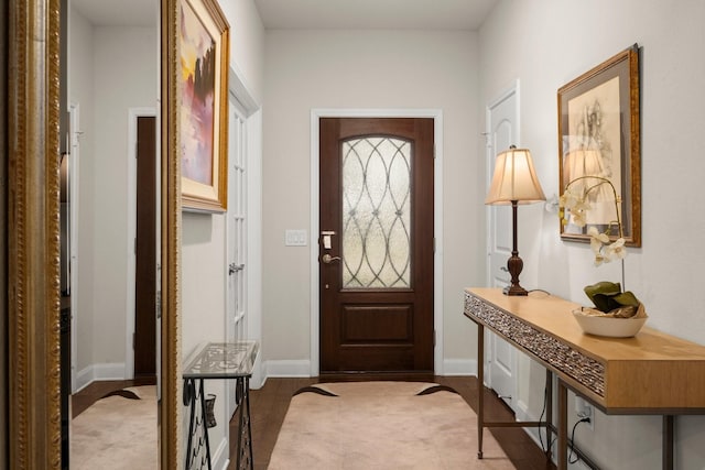 foyer entrance with light wood-style flooring and baseboards