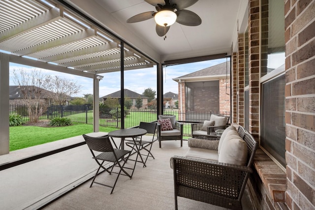 sunroom / solarium featuring ceiling fan and a residential view