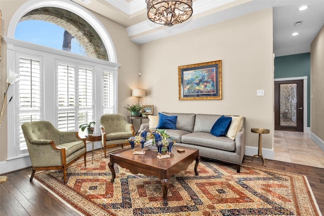 living room with an inviting chandelier, ornamental molding, and dark hardwood / wood-style floors