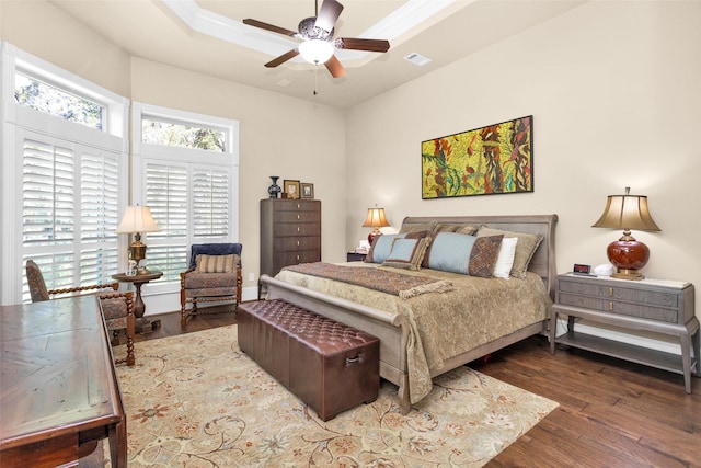 bedroom featuring dark wood-type flooring, ceiling fan, and a tray ceiling