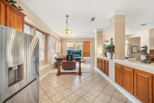 kitchen with decorative light fixtures, stainless steel fridge with ice dispenser, and light tile patterned floors