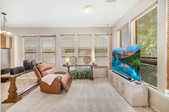 living area with plenty of natural light and light carpet