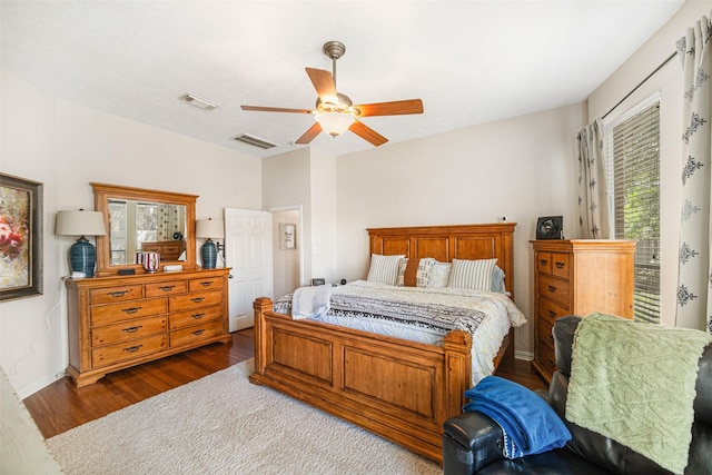 bedroom with multiple windows, dark hardwood / wood-style floors, and ceiling fan