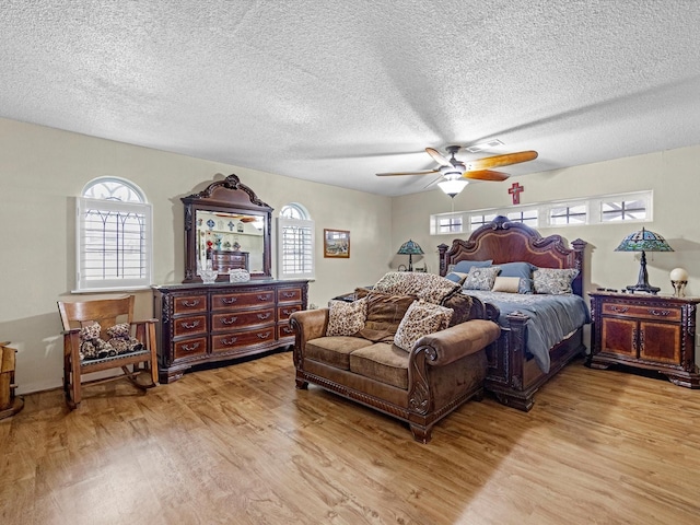 bedroom featuring ceiling fan, a textured ceiling, and light wood-type flooring