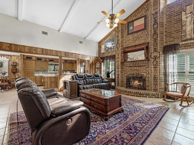 living room with light tile patterned floors, ceiling fan, high vaulted ceiling, a fireplace, and beamed ceiling