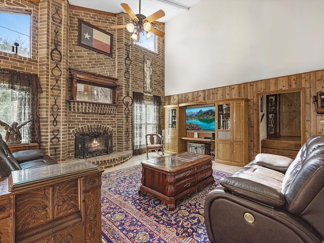 living room featuring a high ceiling, a brick fireplace, ceiling fan, and wood walls