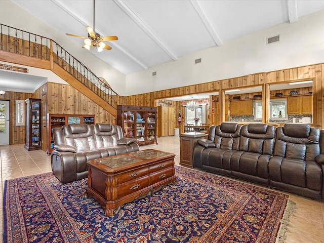 living room with beamed ceiling, wooden walls, high vaulted ceiling, and light tile patterned floors