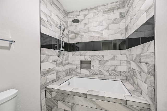 bathroom featuring tiled shower / bath and toilet