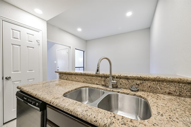 kitchen featuring light stone counters, sink, and dishwasher