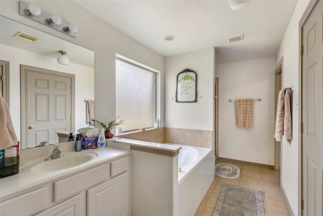 bathroom featuring tile patterned flooring, vanity, and a bath