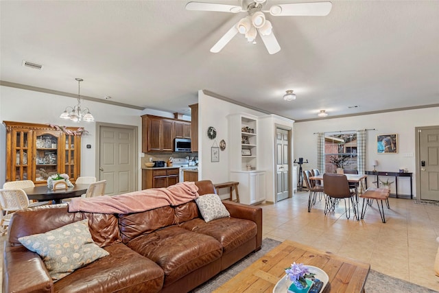 living room with light tile patterned floors, ceiling fan with notable chandelier, and ornamental molding