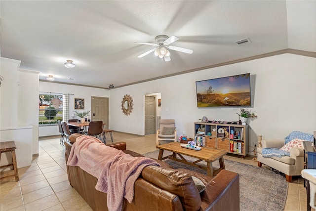 living room featuring ceiling fan, ornamental molding, vaulted ceiling, and light tile patterned floors