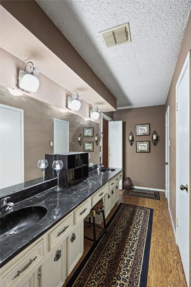 bathroom featuring vanity, hardwood / wood-style floors, and a textured ceiling