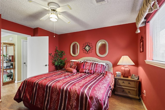 bedroom with ceiling fan and a textured ceiling