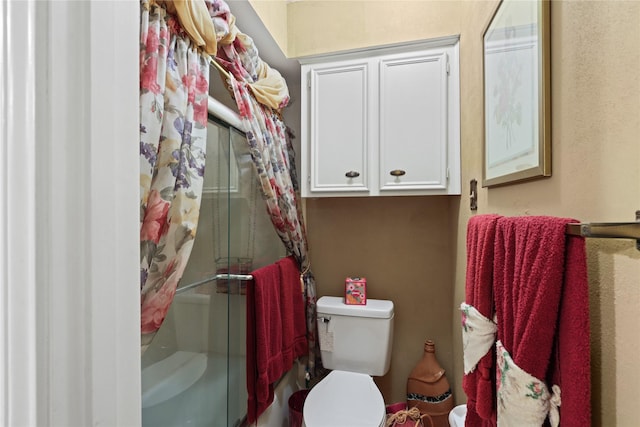 bathroom featuring toilet and an enclosed shower