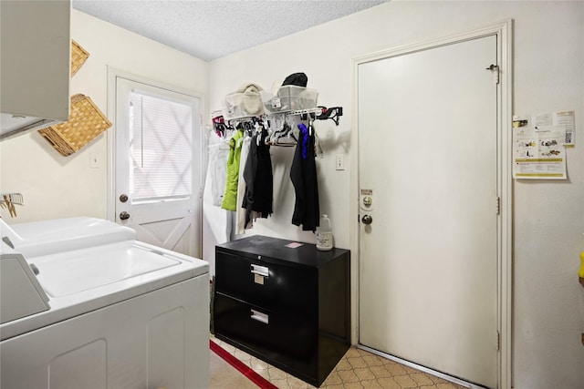 laundry area with washing machine and clothes dryer and a textured ceiling