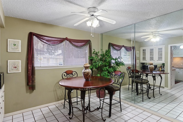 tiled dining space featuring a textured ceiling, plenty of natural light, and ceiling fan