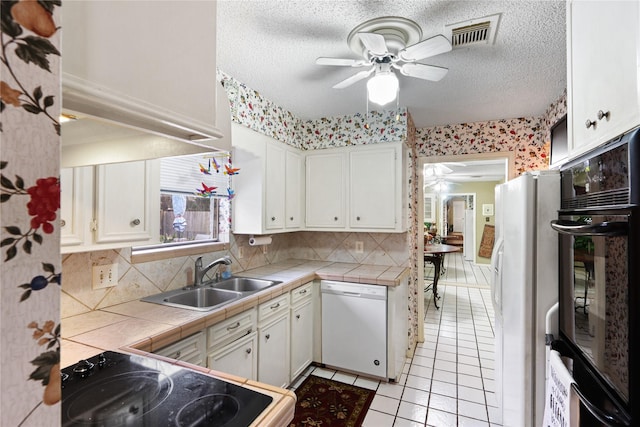 kitchen with sink, white appliances, ceiling fan, white cabinetry, and tile countertops