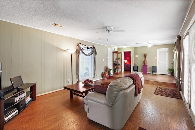 living room featuring a textured ceiling, wood-type flooring, and ceiling fan