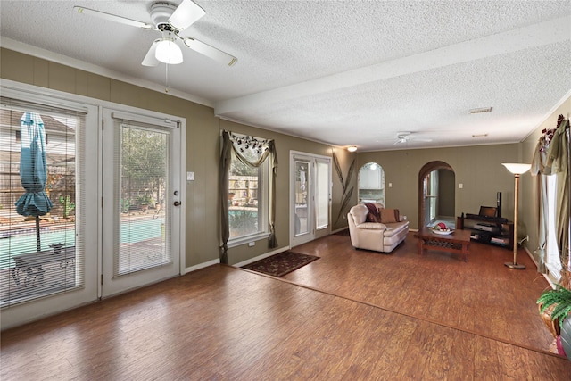 unfurnished living room featuring ceiling fan, dark hardwood / wood-style flooring, and a textured ceiling