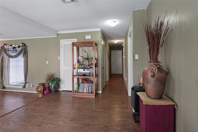 entryway featuring crown molding, dark hardwood / wood-style flooring, and a textured ceiling