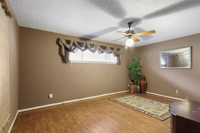 interior space featuring hardwood / wood-style flooring, a textured ceiling, and ceiling fan