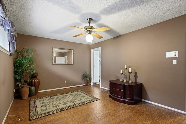 foyer entrance with dark hardwood / wood-style flooring, a textured ceiling, and ceiling fan