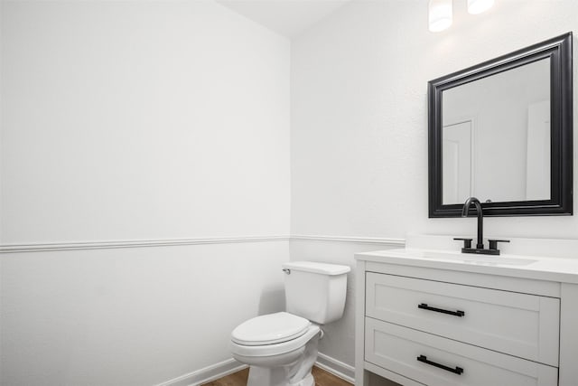 bathroom with vanity, wood-type flooring, and toilet