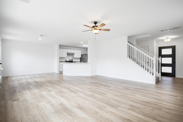 unfurnished living room featuring ceiling fan and light wood-type flooring