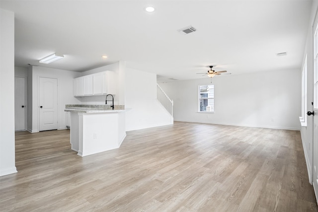 unfurnished living room with light hardwood / wood-style flooring and ceiling fan