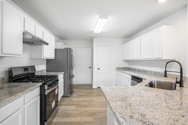 kitchen featuring light stone counters, white cabinetry, stainless steel appliances, and sink