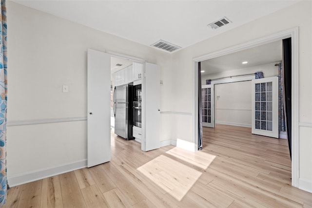 spare room featuring a barn door and light wood-type flooring