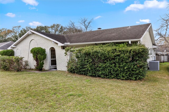 ranch-style house with cooling unit and a front yard