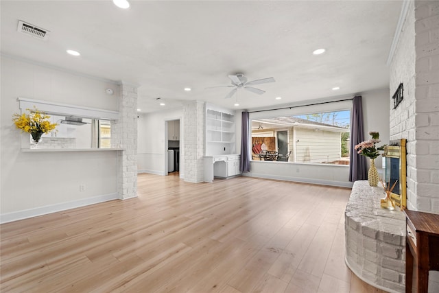 living room featuring ornamental molding, ceiling fan, and light wood-type flooring