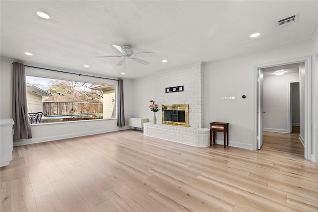 unfurnished living room featuring a fireplace, light hardwood / wood-style floors, and ceiling fan