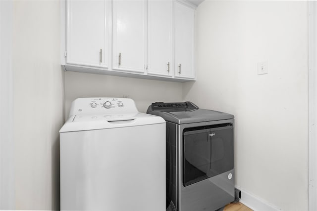 washroom featuring cabinets and washing machine and clothes dryer