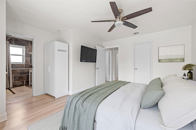 bedroom with ceiling fan, hardwood / wood-style floors, and ensuite bath