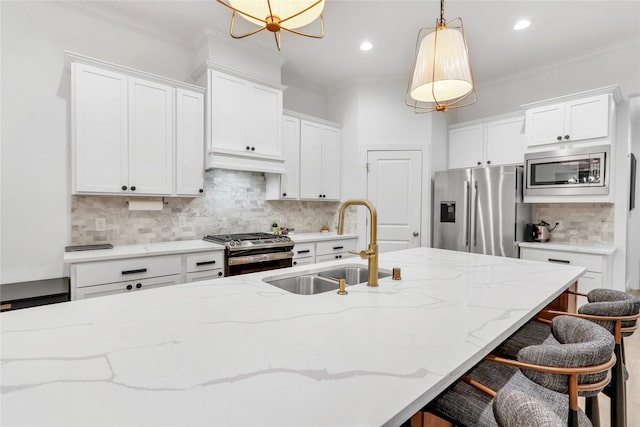 kitchen with stainless steel appliances, sink, white cabinets, and decorative light fixtures