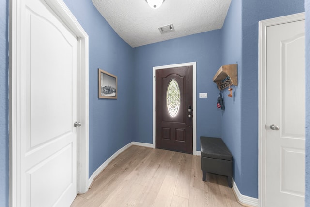 foyer with a textured ceiling and light wood-type flooring