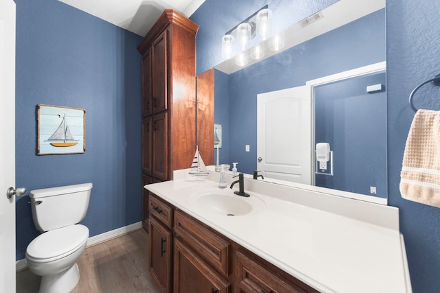 bathroom featuring vanity, toilet, and hardwood / wood-style floors