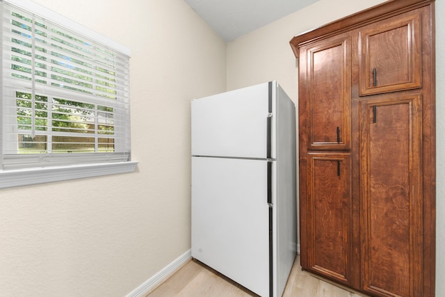 kitchen with white refrigerator and light hardwood / wood-style floors