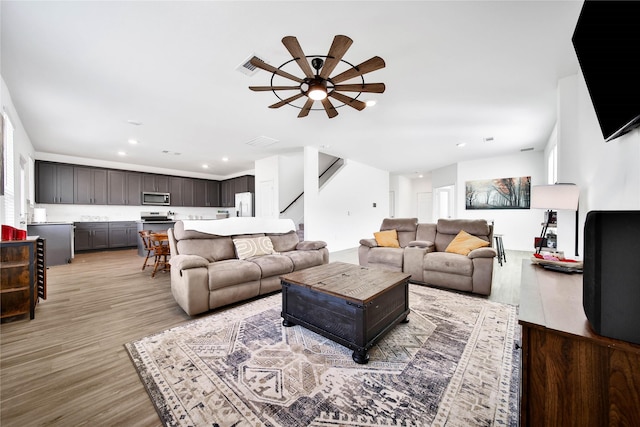 living room featuring ceiling fan and light hardwood / wood-style floors